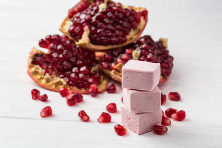 pink marshmallow handmade and pomegranate on the tableの写真素材