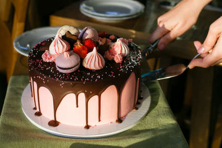 cutting a strawberry cake, against the background of a plate