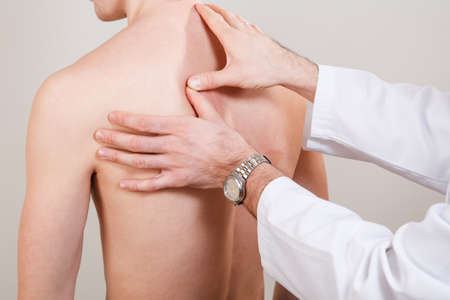 Chiropractic, osteopathy, manual therapy, acupressure. Therapist doing healing treatment on man's back. Alternative medicine, pain relief conceptの写真素材