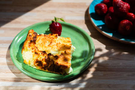 Appetizing homemade casserole and strawberries on the tableの写真素材