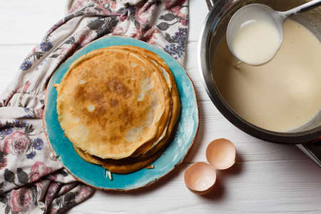 Pancakes and a bowl with a test on the table. Flat layの写真素材