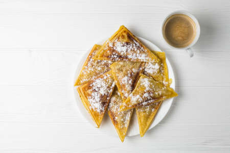 Homemade patties on a plate and a cup of coffee. Flat lay on white wooden tableの写真素材