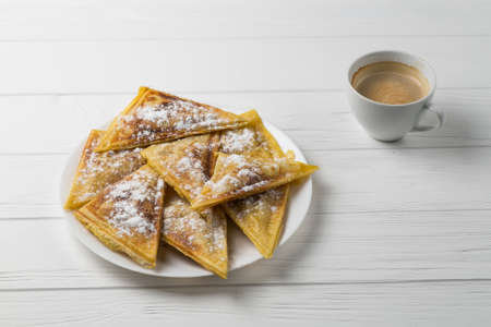 Homemade patties on a plate and a cup of coffee. Flat lay on white wooden table