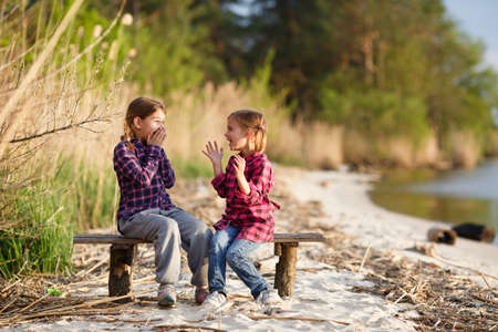 Two girls play and have fun on the beach. Sunset.の写真素材