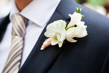 white freesia pinned to the lapel of the groom