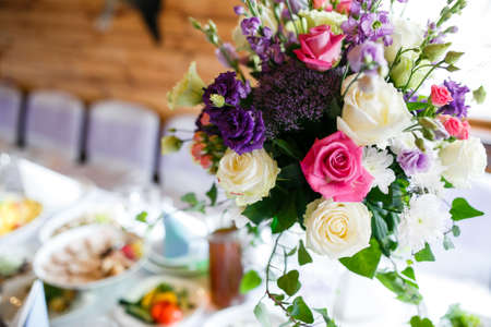 Served with plates, a table decorated with a bouquet of flowers.