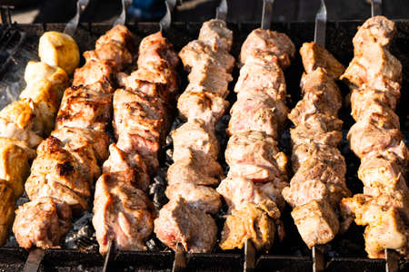 fresh grilled meat on skewers on grill close up