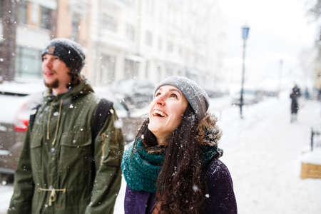Young couple on the city street under the snowfallの写真素材