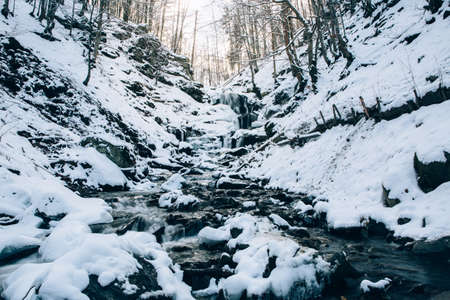 Beautiful Shypit Waterfal and rocks covered with snow. Shypit waterfall located on Pylypets River in the Carpathian Mountains, near village of Pylypets, Western Ukraine, Europe.の写真素材