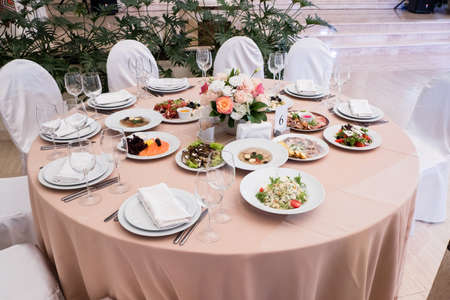 Served for banquet restaurant table with dishes, snack, cutlery, wine and water glasses.の写真素材