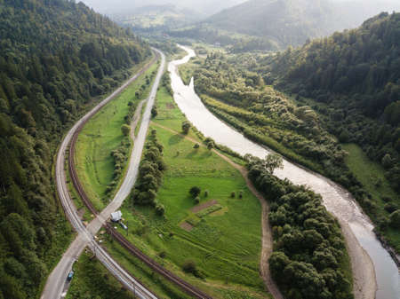 Aerial view to road with moutains and river captured from above, carpathians mountains
