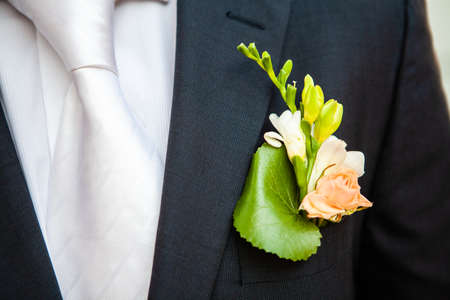 white freesia pinned to the lapel of the groom