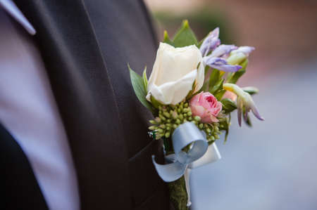 white freesia pinned to the lapel of the groom