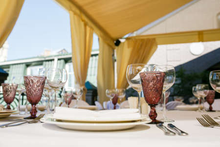 Served for banquet restaurant table with dishes, snack, cutlery, wine and water glasses.