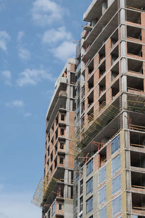 Part of the house under brick construction. Empty windows and doors. Under construction