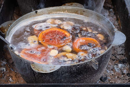 Mulled hot wine, spiced wine, beverage made with red wine with various mulling spices in large...