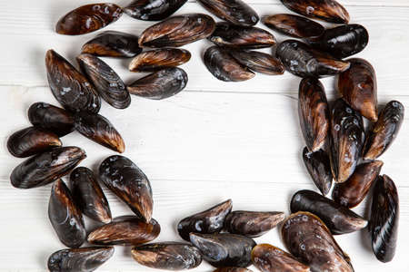Fresh raw mussels on white wooden vintage backgound with place for text