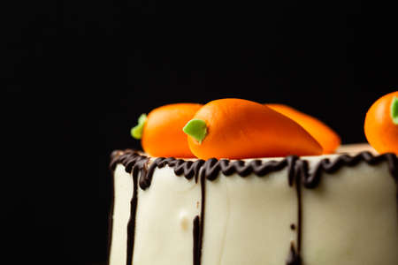homemade cake with carrot decor on black background