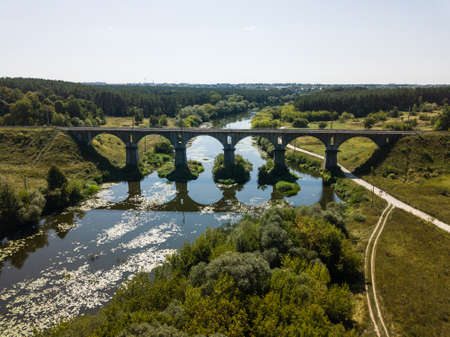 Aerila view to beautiful railway bridge viaduct over the river Sluch near Novograd Volynsky, Ukraine. The bridge is built according to a special technology: without cement, with a solution mixed with chicken eggsの写真素材