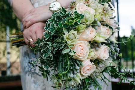 Beautiful wedding bouquet in hands of the brideの写真素材