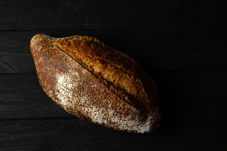 Rye bread ciabatta on a black wooden background