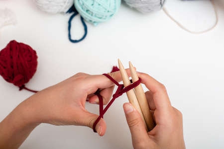 Children hands are knitted and crocheted view frome above on white table