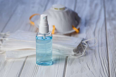 Hand sanitizer antibacterial antiseptic gel, face mask and respirator on white wooden table . Coronavirus Disease Covid-19 prevention and health protection during flu virus outbreak conceptの写真素材