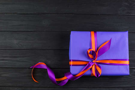 Blue gift box with red ribbon on black wooden table. Boxing dayの写真素材