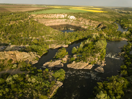 Aerial view to granite mountains and rapids on Southern Bug river, surrounded by trees and grasses, Mihiia village. Ukraine. Famous place for rafting and kayakingの写真素材