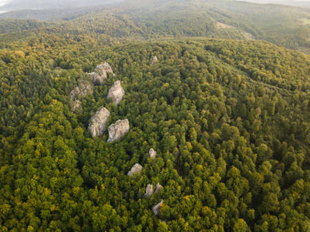 Aerial view to Dovbush Rocks in Bubnyshche at sunrise. Legendary ancient cave monastery in fantastic boulders amidst beautiful scenic forests in Carpathian Mountains, Ukraineの写真素材