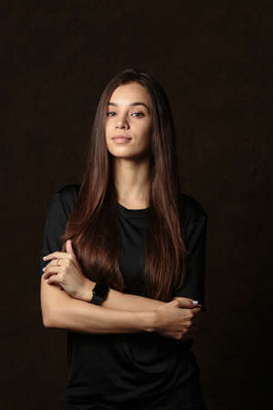 Sporty girl in special sportswear staying with big fitness ball on dark backgroundの写真素材