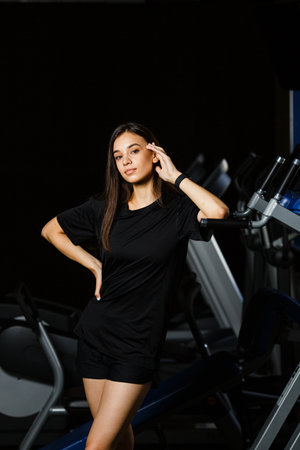 Sporty girl in fashionable sportswear stay near by sport equipment in sport clubの写真素材