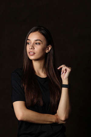 Sporty girl in special sportswear staying with big fitness ball on dark backgroundの写真素材