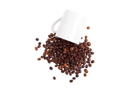 Overturned white mug with coffee beans, top viewの写真素材