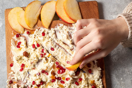 Trendy sweet butter board. Childrens hands hold apple slices over the board.の写真素材