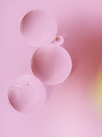 Abstract bubbles background in pale pink and powdery colors. Macro drops of oil on the surface of...