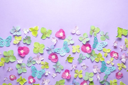 Floral background of colorful hydrangeas and pink paper butterflies. Top view. Festive flat lay and copy space.の写真素材
