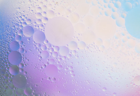 Beautiful small bubbles of oil on surface of the water. Delicate cosmetic background for advertising products. copy space.の写真素材