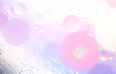 Abstract background in pink and lilac soft tones. Macro drops of oil on surface of the water. Delicate cosmetic background for advertising products.の写真素材