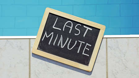 Last minute written on a chalkboard at a poolの写真素材