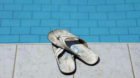 Used men white flip flops at a poolの写真素材