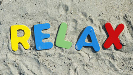 Relax written with wooden letters on the beachの写真素材