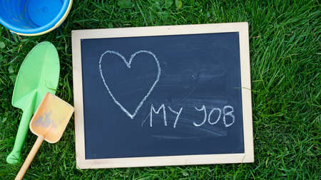 love my job written on a chalkboard between child toysの写真素材