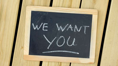 We want you written on a chalkboard on woodの写真素材