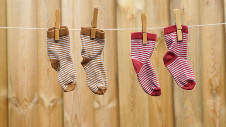 Two pair off child socks are hanging at the clotheslinein the sun
