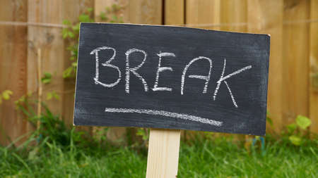 Break written on a chalkboard in the garden