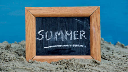  Summer writteen on a chalkboard at the beachの写真素材