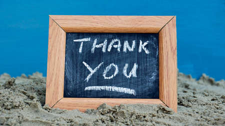 Thank you written on a chalkboard at the beachの写真素材