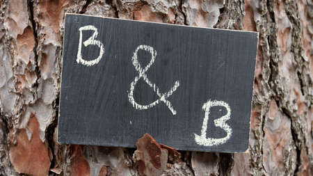 B and B written on a chalkboard hanging at a treeの写真素材