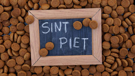 Pile of Pepernoten, typical Dutch treat for Sinterklaas on 5 december written on a chalkboardの写真素材